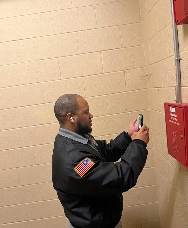 SecurityRI officer scanning QR patrol checkpoint at residential property